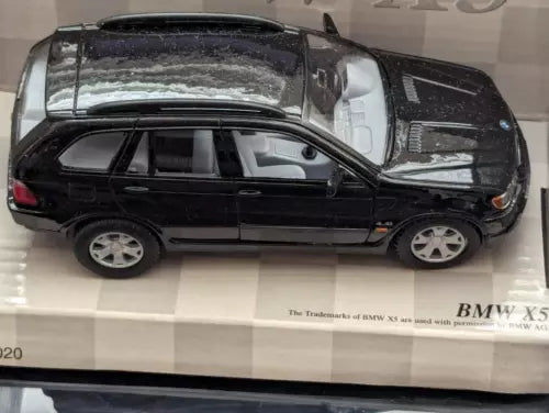 Kinsmart 1:36 scale black SUV diecast toy in box, side view with visible wheels