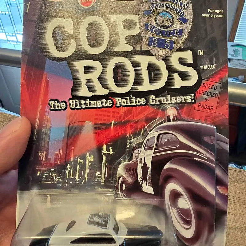 Diecast police cruiser car in Hot Wheels blister packaging, dark maroon and white