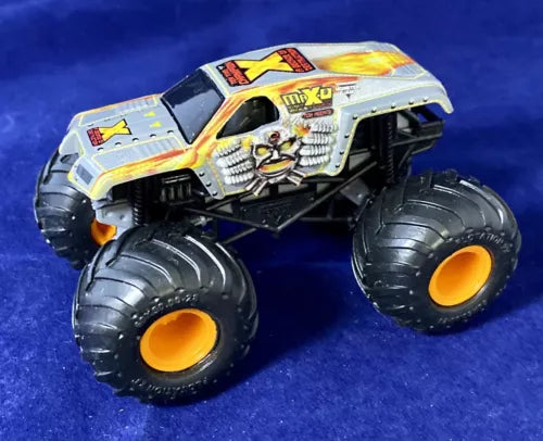 Diecast monster truck with silver body, skull graphic, and oversized black wheels