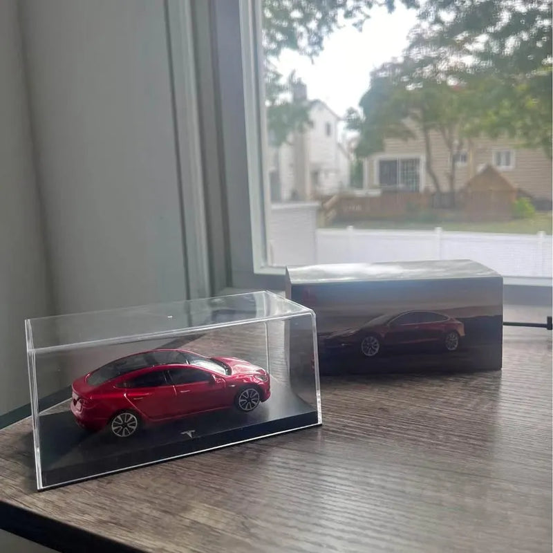 Red Tesla Model 3 diecast sedan in clear display case with blue base