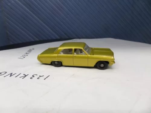 Vintage diecast toy car, yellow sedan with black wheels