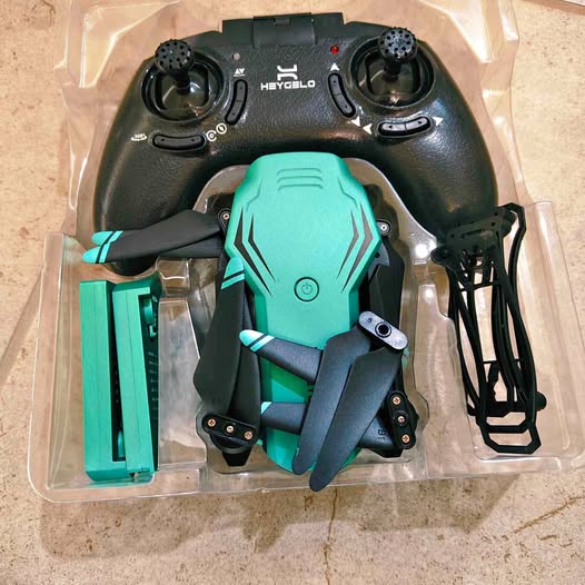 Teal quadcopter drone with remote controller in retail packaging