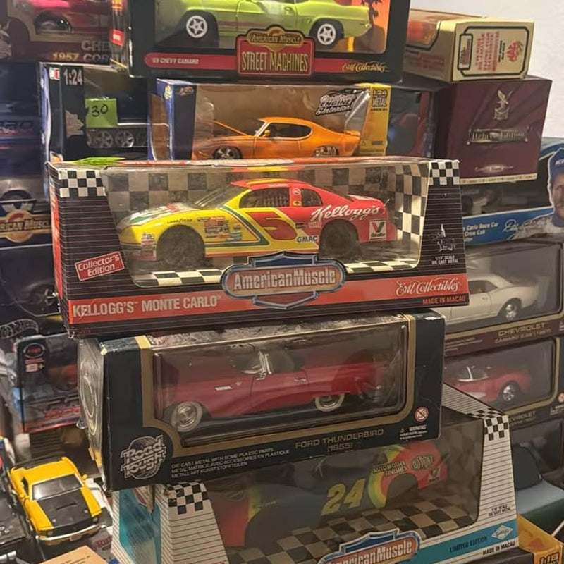 Die-cast race car toy in retail box, orange and yellow with checkered graphics