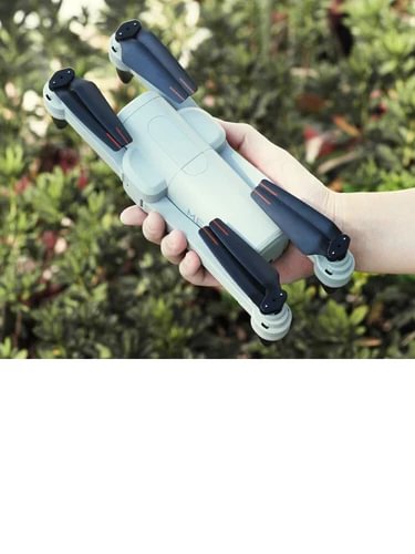 Light blue four-axis drone with propellers, held in hand