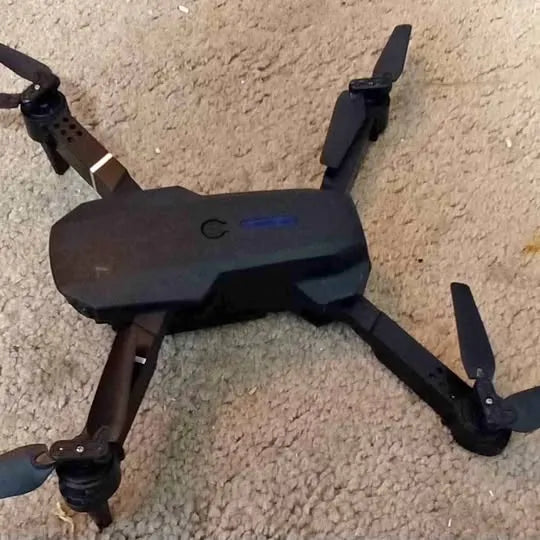Black foldable quadcopter drone with camera, four prop arms