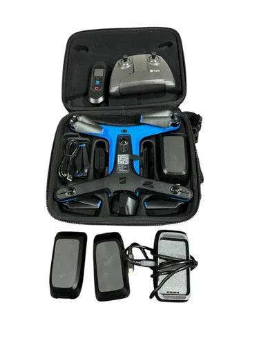Drone accessory kit in open case with controller, batteries, charger, and beacon