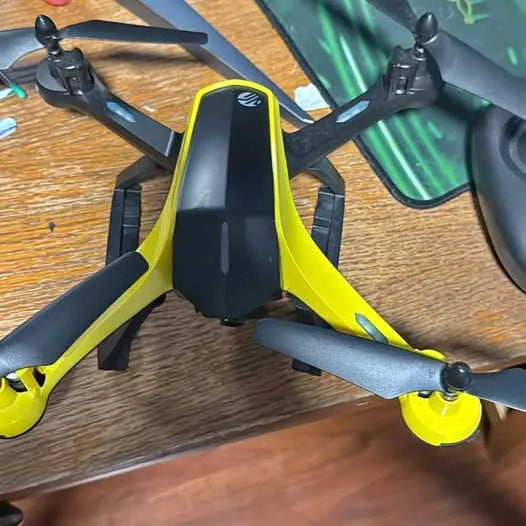 Yellow and black quadcopter drone with four propellers and central camera housing