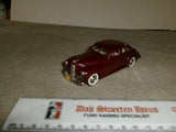Red diecast sedan model car with chrome bumpers and whitewall tires