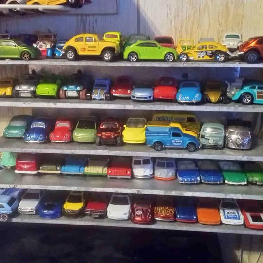 Diecast car lot, many 1/64 vehicles in rows, assorted colors and classic styles.