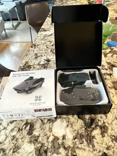 Quadcopter drone kit in open box with remote controller and quadcopter drone