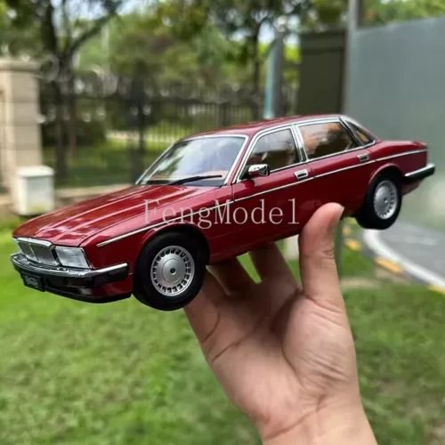 Red metal diecast car model, front three-quarter view with chrome grille and headlights.