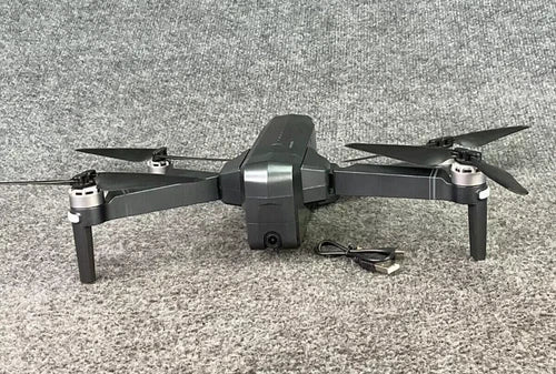 Foldable black quad-copter drone with camera, four propellers and central body