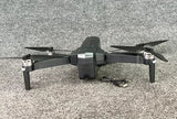 Foldable black quad-copter drone with camera, four propellers and central body
