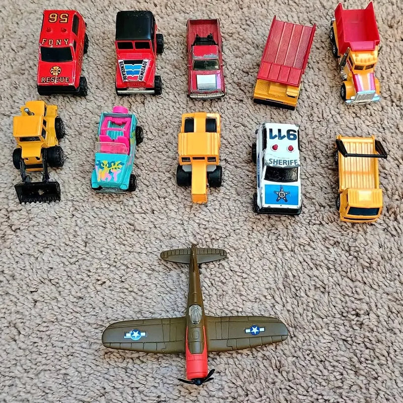 Assorted diecast toy cars and a green propeller airplane model