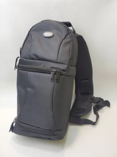 Dark gray sling backpack with front zip pocket and padded shoulder strap