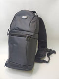 Dark gray sling backpack with front zip pocket and padded shoulder strap