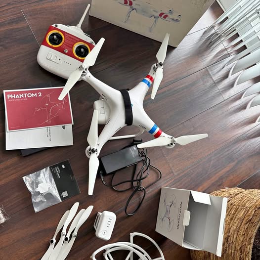 DJI Phantom 2 drone, white body with red accents, four propellers; kit papers