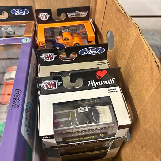 M2 diecast model car in retail box, white and black with Plymouth logo
