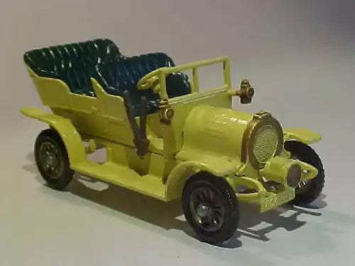 Vintage yellow diecast car, open cockpit, black seats, side view.