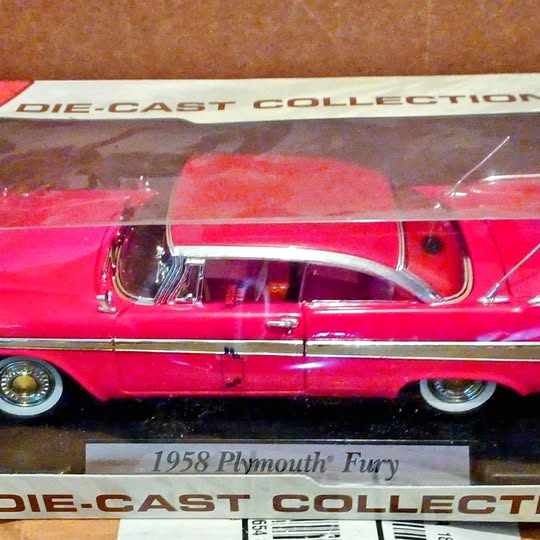 Die-cast collectible car, red 1958 Plymouth Fury with white roof and chrome front details