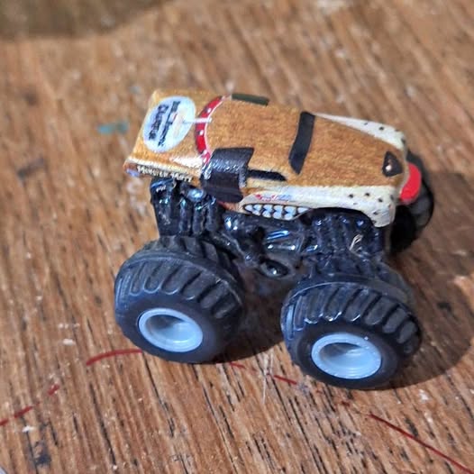 Diecast pull-back car, brown cab with white roof and black oversized wheels