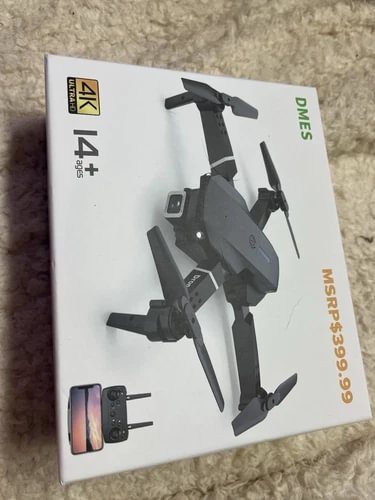 Foldable dark gray quadcopter drone with remote in retail box