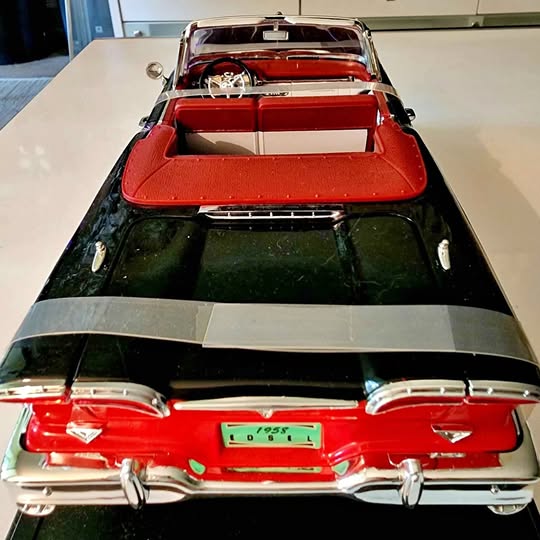Red and black metal diecast car with chrome rear bumper and tail lights