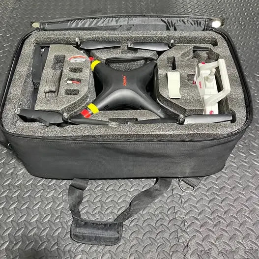 Black 4-channel RC drone kit in foam-lined hard travel case with accessories