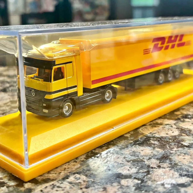 Yellow DHL diecast Mercedes tractor-trailer replica in clear display case