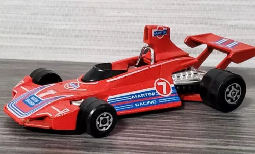 Red Formula 1 diecast race car with black tires and Martini-style decals