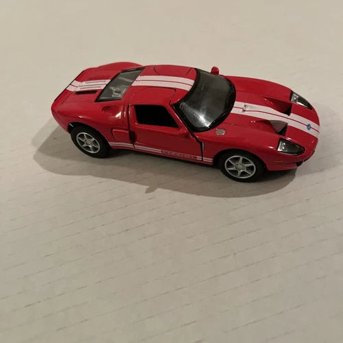 Red 1/36 scale Ford GT diecast model car with white racing stripes and black wheels