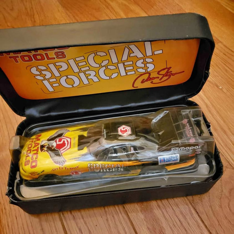 Diecast funny car model in black box with yellow and orange graphics