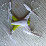 White and green quadcopter drone with four propellers and protective guards