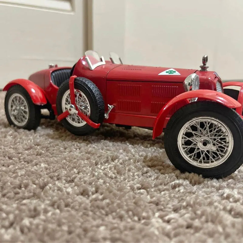 Red vintage race car diecast model, 1:18 scale, open wheels and hood.