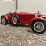 Red vintage race car diecast model, 1:18 scale, open wheels and hood.