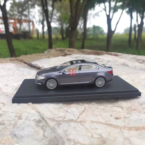 Diecast concept car model, dark gray sedan on display base, side view