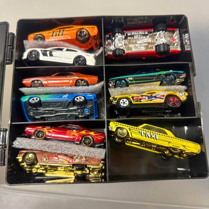 Hot Wheels diecast muscle car lot in open display case, multiple colored cars visible