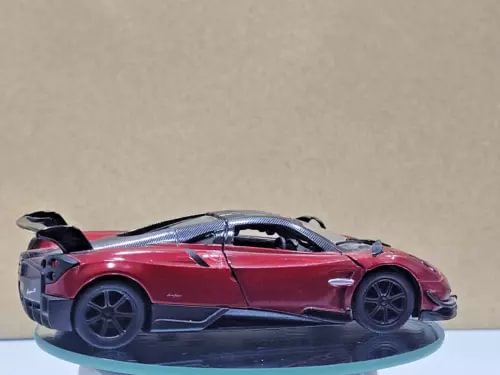 Red diecast sports car model toy with black wheels and black rear spoiler