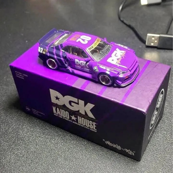Purple diecast R34 car model on DGK Kaido House logo box