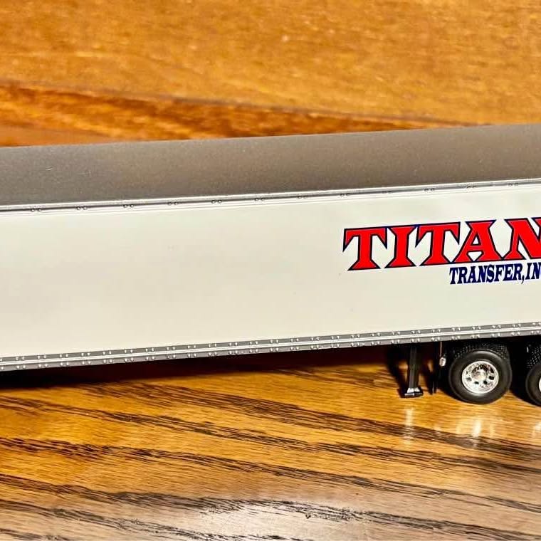 Diecast Titan transfer tractor trailer replica, gray semi-trailer with Titan logo and wheels.
