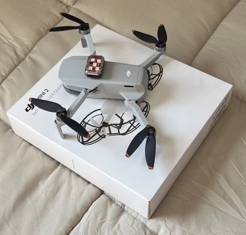 DJI Mini 2 drone with attached controller and propellers, Fly More combo accessories
