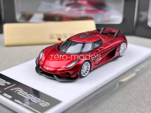 Red diecast sports car model with black wheels, front three-quarter view on display base