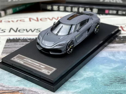 Grey diecast Koenigsegg Gemera model car on black display base, front 3/4 view