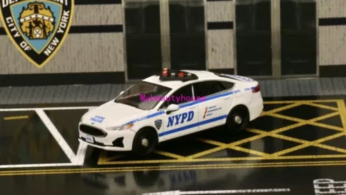 Diecast metal police model car with NYPD livery, white and blue, front 3/4 view