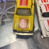 Yellow diecast toy car, front close-up with grille details
