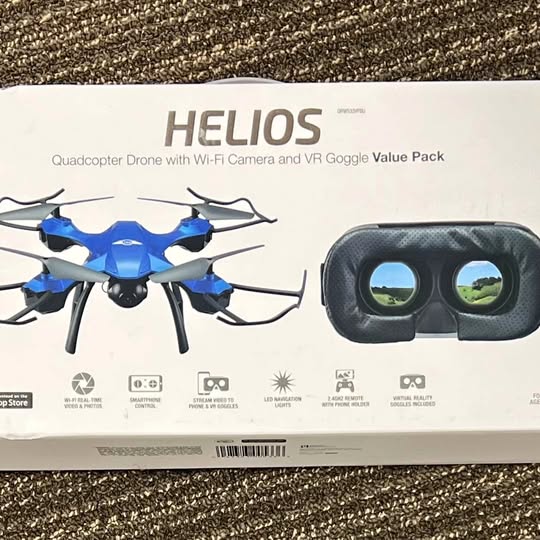 Helios quadcopter drone with blue propellers and VR goggles on retail box