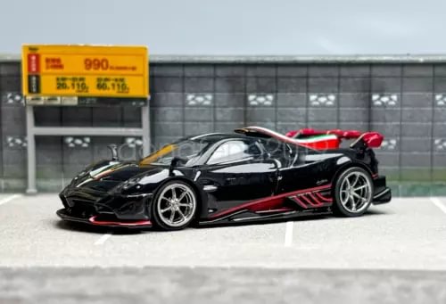 Black 1:64 racing diecast sports car with red accents, front 3/4 view.