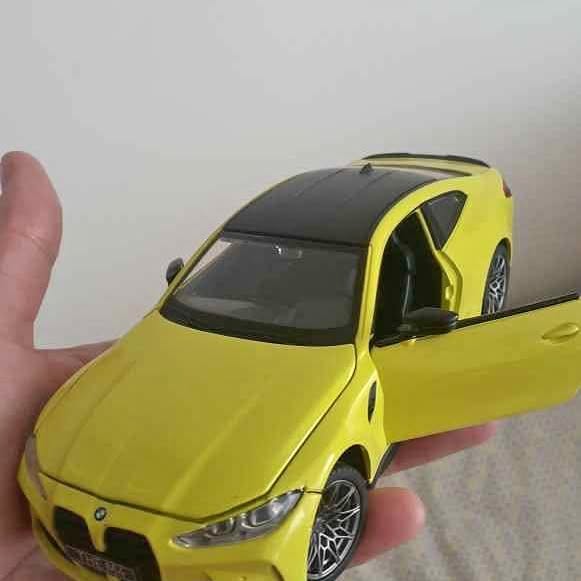 Yellow diecast model car with black hood and windshield, front three-quarter view