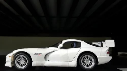 White 1:18 diecast racing model car with open-wheel styling, side view