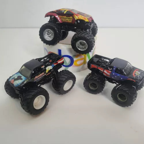 Black diecast monster truck with colorful racing decals, large off-road wheels